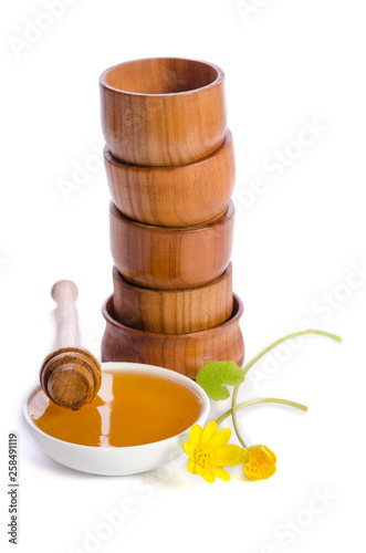 honey in the glass bowl  and tower frow wooden bowls near isolated on white background photo