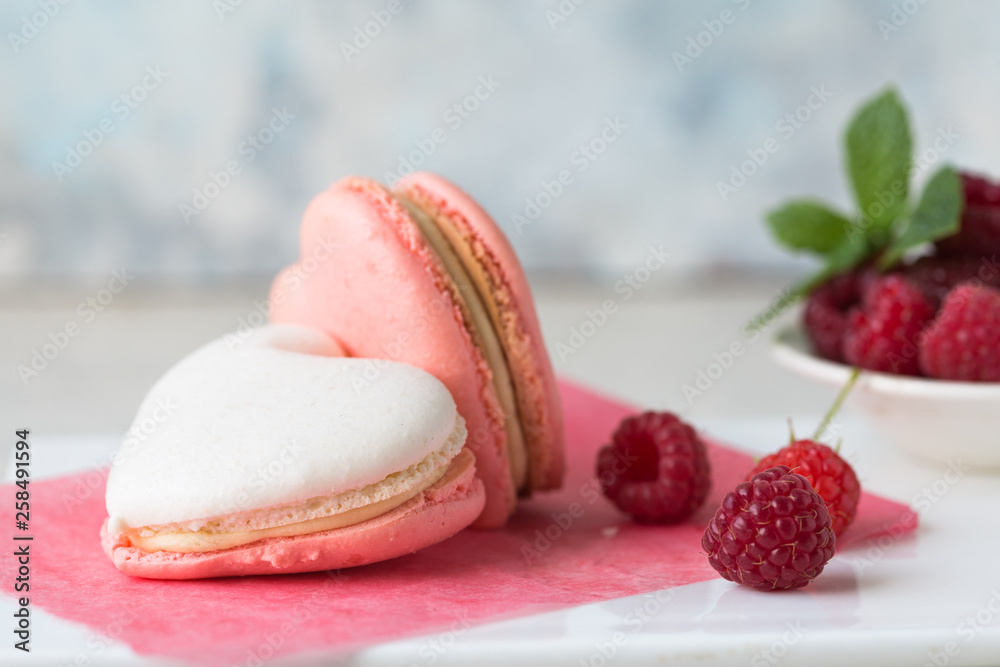 A beautiful heart made of macaroons and raspberry. Valentines day consept. flat lay, top view. A beautiful heart made of macaroons and raspberry. Valentines day consept. flat lay, top view.