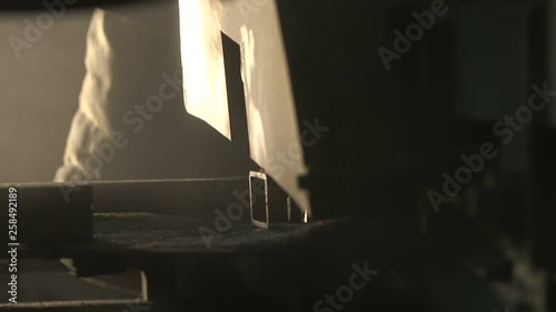 Heavy side grinder cutting a large metallic pipe with flying yellow sparkles