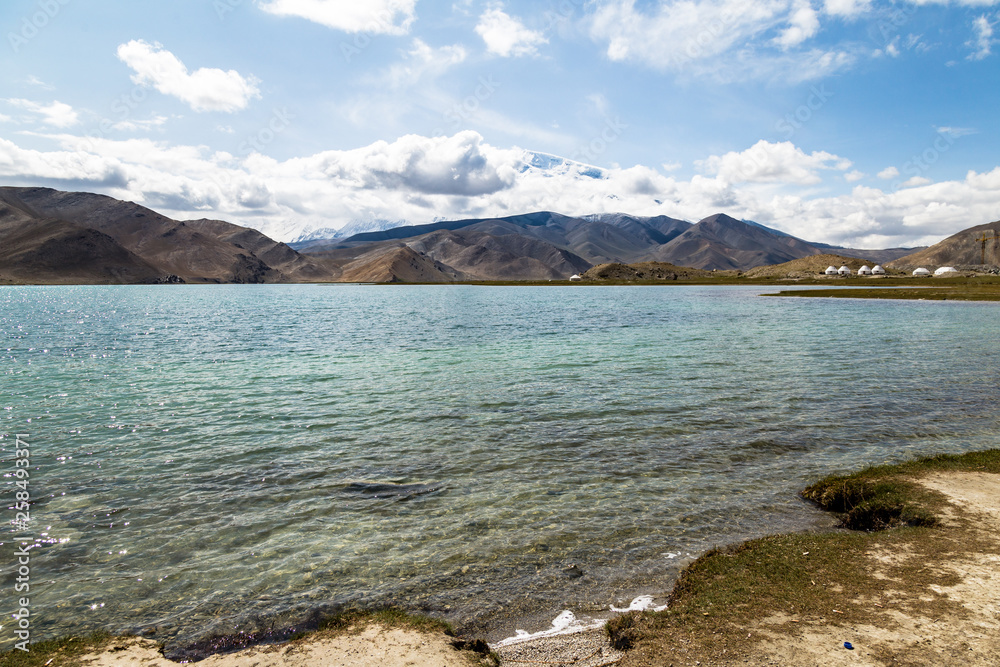Karakul Lake along Karakorum Highway, Xinjiang, China, connecting Kashgar and the Pakistan border. 3600m, it is the highest lake in Pamir Plateau. Mt. Kongur, 7700m, is visible in the background Karakul Lake along Karakorum Highway, Xinjiang, China, connecting Kashgar and the Pakistan border. 3600m, it is the highest lake in Pamir Plateau. Mt. Kongur, 7700m, is visible in the background