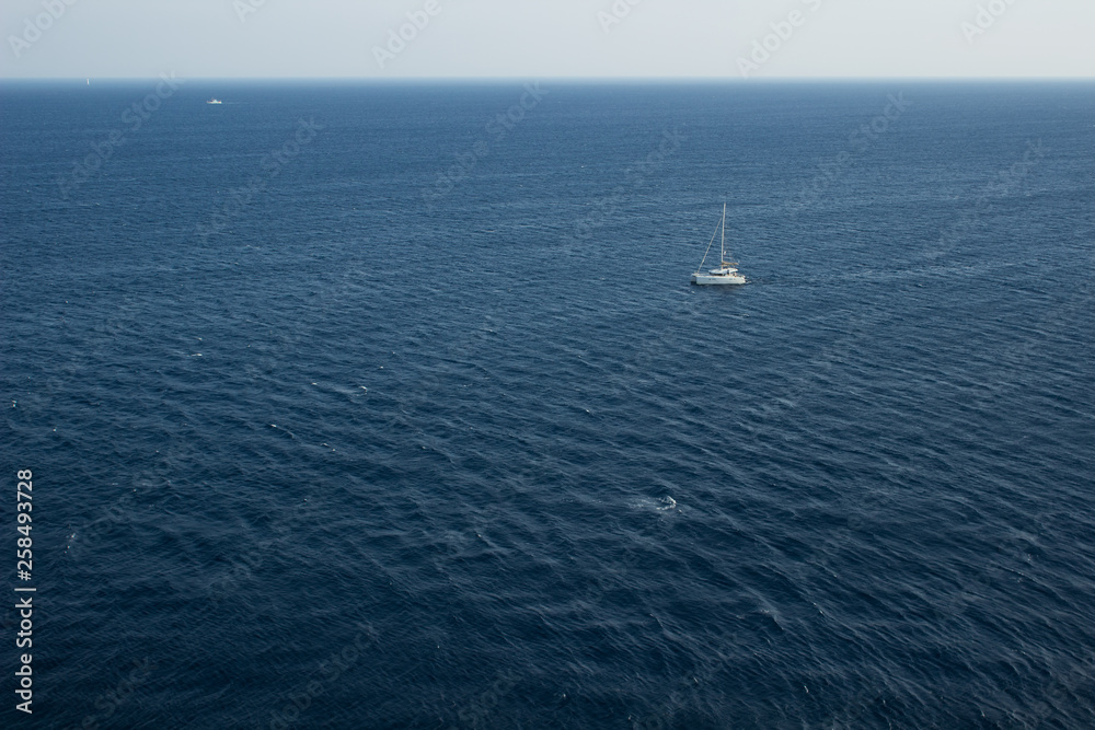 simple scenery landscape pattern summer cruise vacation concept of single walking yacht in water environment in Mediterranean sea not far from Greece coast line, copy space in aerial photography simple scenery landscape pattern summer cruise vacation concept of single walking yacht in water environment in Mediterranean sea not far from Greece coast line, copy space in aerial photography