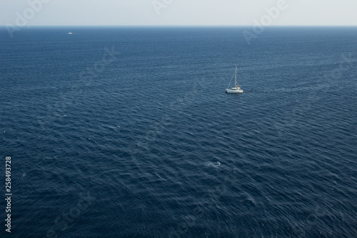simple scenery landscape pattern summer cruise vacation concept of single walking yacht in water environment in Mediterranean sea not far from Greece coast line, copy space in aerial photography