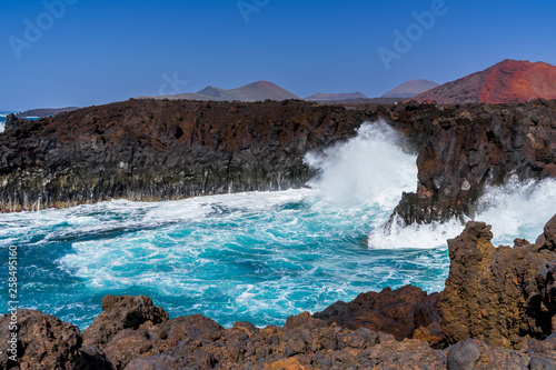 Spain, Lanzarote, White spindrift of breaking waves in los hervideros volcanic cove