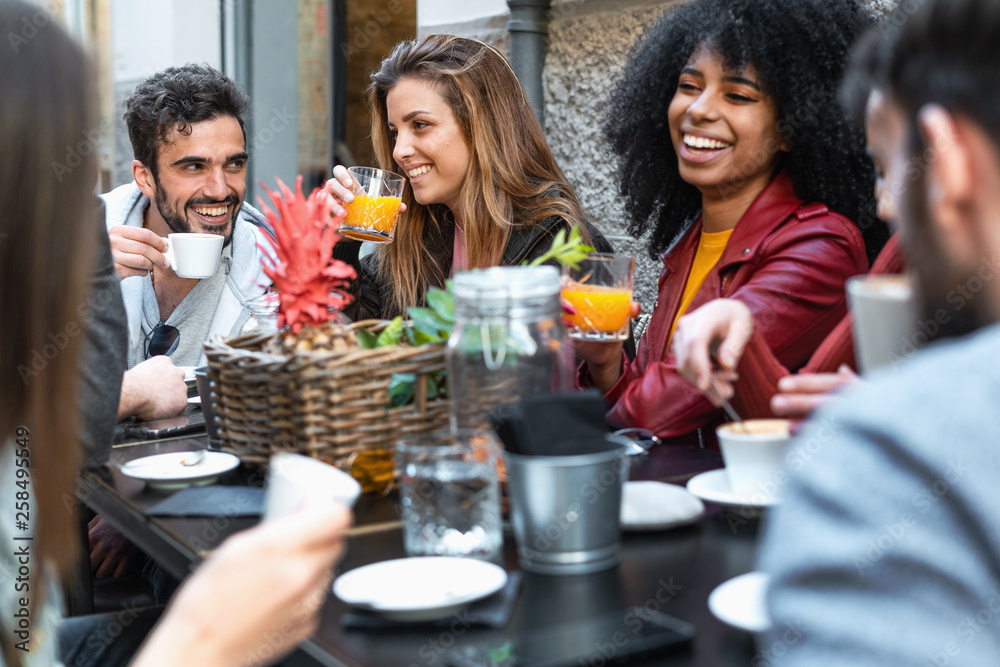 Group of multiracial friends having fun time in a coffee drinking coffee cappuccino and fruit juice