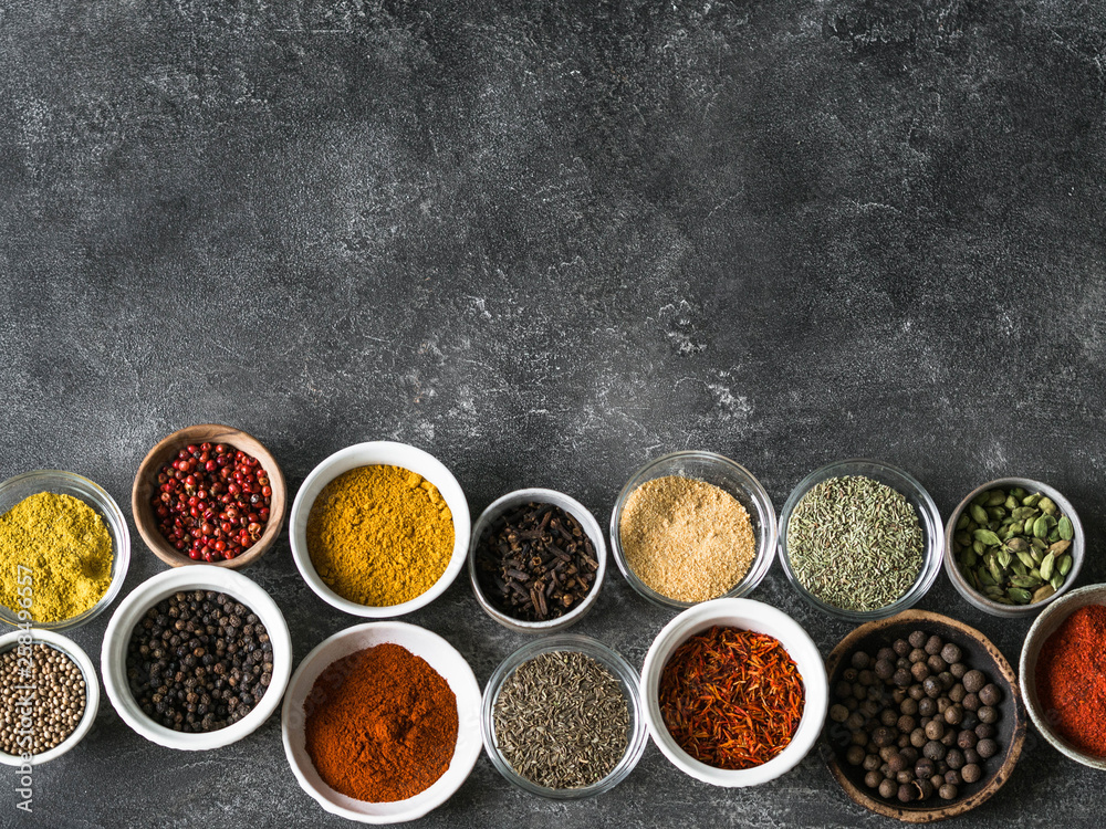 Various dry spices flat lay in small bowls on gray background. Top view, copy space Various dry spices flat lay in small bowls on gray background. Top view, copy space