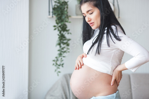 Young pregnant woman having a backache. Expecting woman feeling bad. Pregnant woman suffering from pain. Free Download Young pregnant woman having a backache. Expecting woman feeling bad. Pregnant woman suffering from pain. - GFXLoad