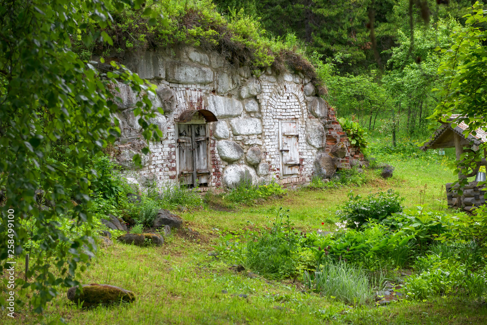 SOLOVKI, REPUBLIC OF KARELIA, RUSSIA - JUNE 27, 2018: Old cellar in the Botanical garden on Solovki. Solovki Islands, Arkhangelsk region, White Sea SOLOVKI, REPUBLIC OF KARELIA, RUSSIA - JUNE 27, 2018: Old cellar in the Botanical garden on Solovki. Solovki Islands, Arkhangelsk region, White Sea