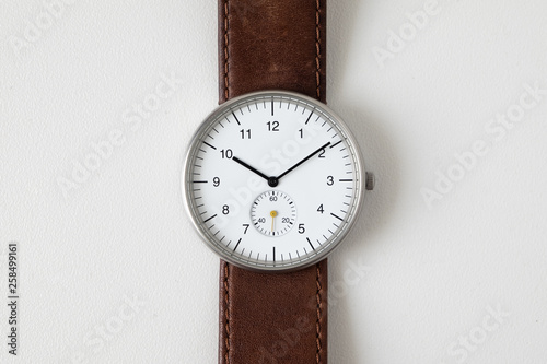 Minimalist watch wristwatch with white dial and brown leather strap isolated on white background