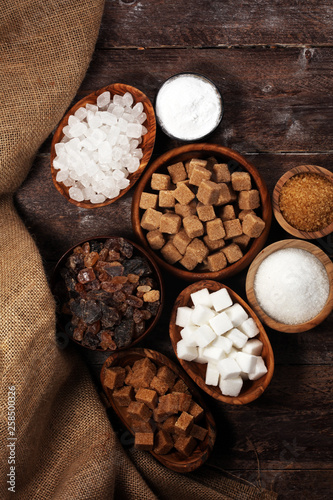 Various types of sugar, brown sugar and white on rustic wooden table