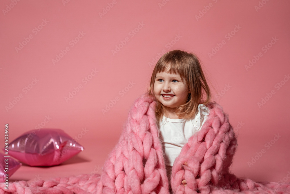 happy baby on pink coral background covered with blanket and Merino. with free text space. happy baby on pink coral background covered with blanket and Merino. with free text space.