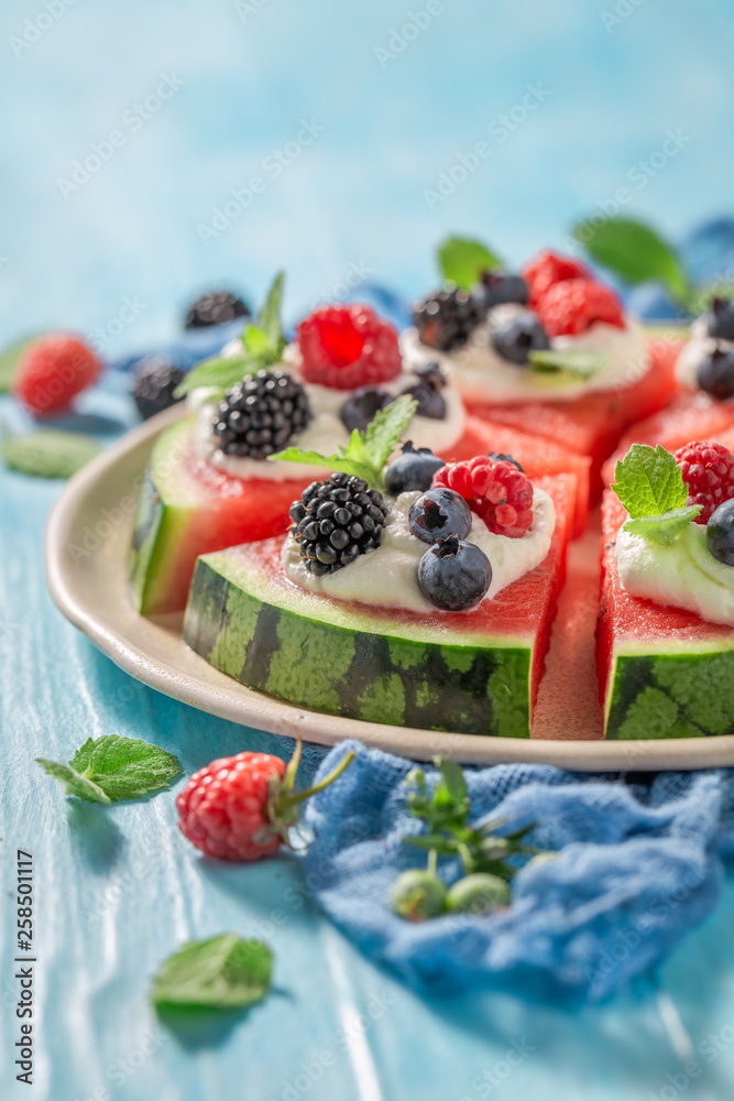 Fresh watermelon pizza with whipped cream and fresh berry fruits