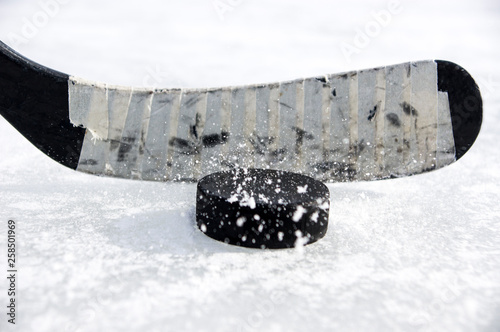 ice hockey stick and puck with snow splashes