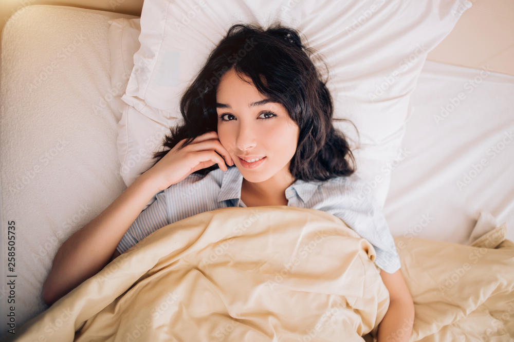 Portrait pretty young girl on bed in modern apartment in the morning Portrait pretty young girl on bed in modern apartment in the morning