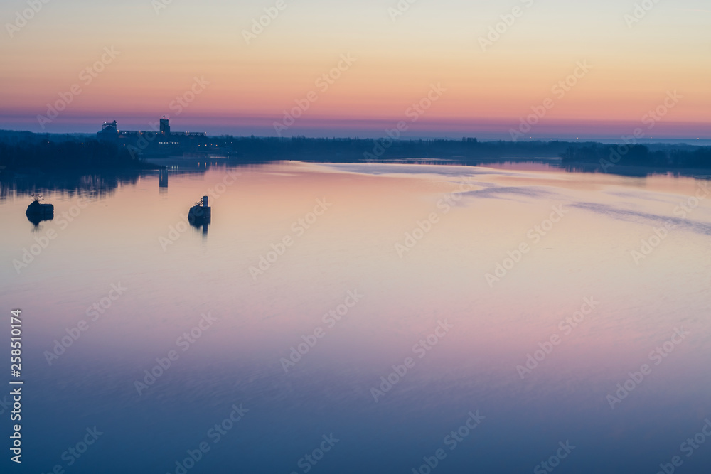 Scenic sunset over the calm water surface.
