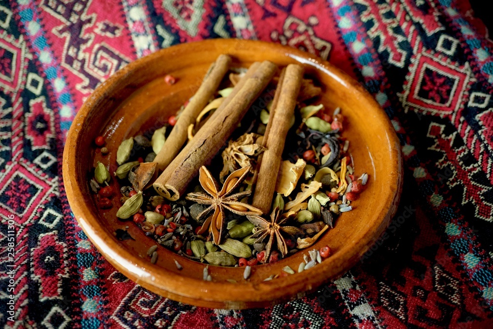 Fototapeta premium Ceramic bowl on arabic fabric with mixed spices