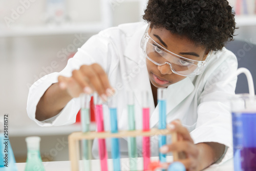 female scientist examining samples in test tube rack