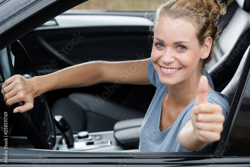 cute woman giving thumb up inside her car