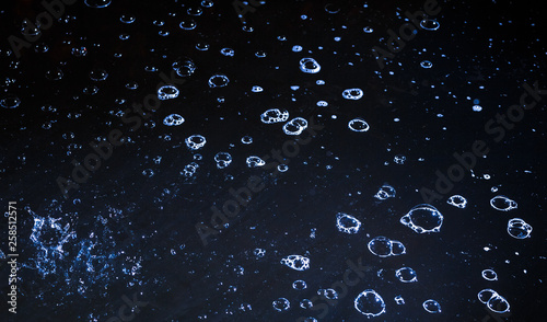 Bubbles on the water during the rain at night.