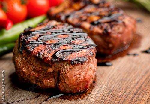 grilled beef steak with vegetables on wooden background
