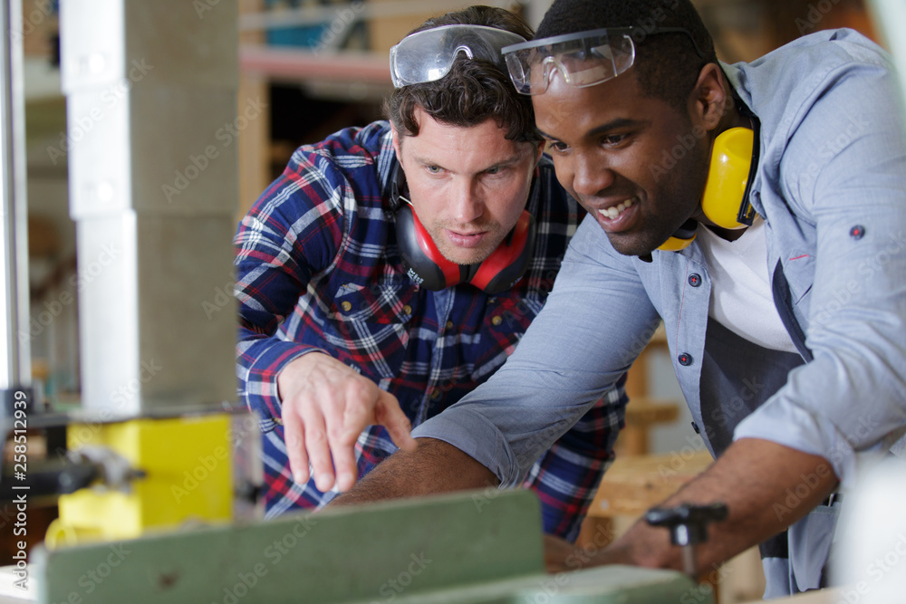 production workers cutting wood in a factory