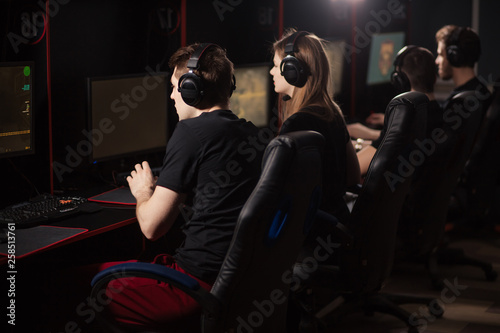 Competition, Entertainment, Computer Addiction concept. Th way of earning money combined with enjoyment and interest. Back view of young gamers concentrated on e cport competitive game.