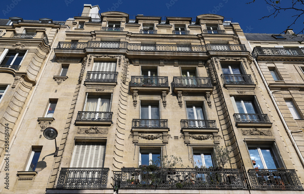 Traditional French house with typical balconies and windows. Paris.