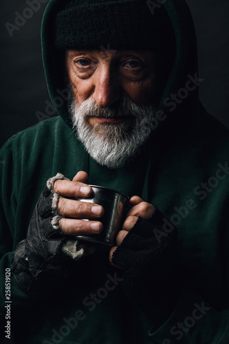 Fotografia Frozen homeless bearded old man with grey hair and wrinkled face, looks at camer