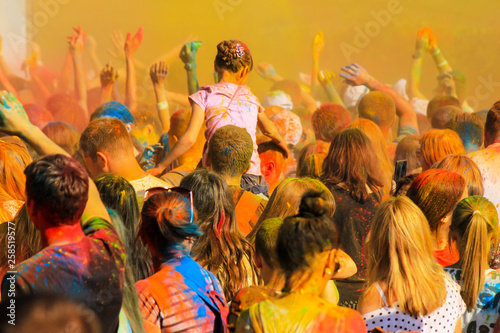 A crowd of young people scatters multicolored paint on the Holi festival. Teens having fun at the festival of oriental culture. Dnipro, Dnepropetrovsk, Ukraine