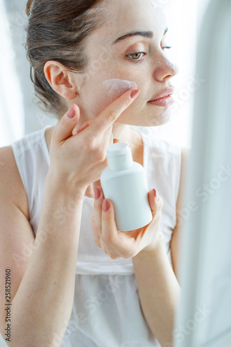 Fototapeta Naklejka Na Ścianę i Meble -  Woman applying cream