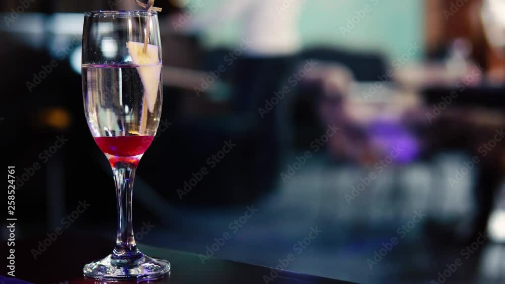 Blurred image of the interior of the restaurant. A glass of wine in the foreground. Blurred image of the interior of the restaurant. A glass of wine in the foreground.