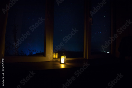 Night scene of stars seen through the window from dark room. Night sky inside dark room. Long exposure shot