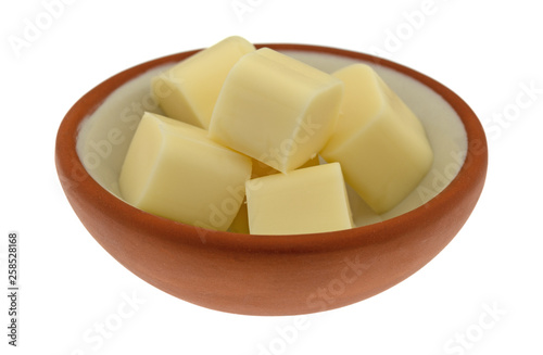 Small bowl of mozzarella string cheese pieces on a white background