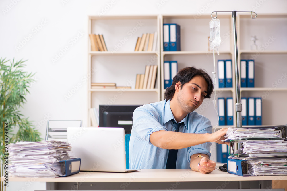 Young male employee in blood transfusion concept Young male employee in blood transfusion concept