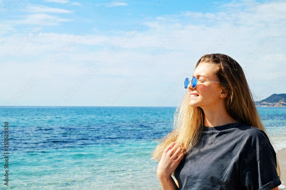 Portrait of young beautiful woman in tropical destination island beach with the ocean background. Joy of summer holidays concept. Close up, copy space