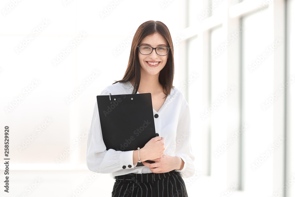 smiling businesswoman with documents standing in the office. smiling businesswoman with documents standing in the office.