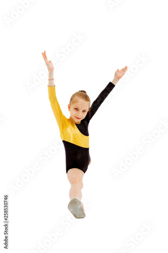 Little girl gymnast sitting in the splits. Isolated on white