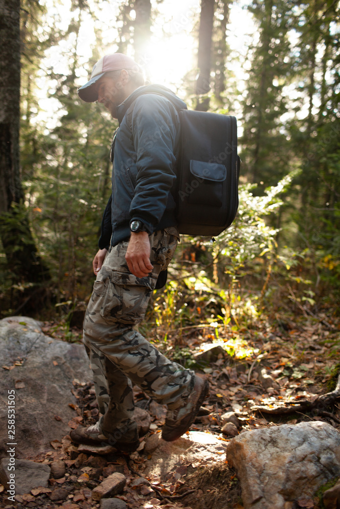 Man hiking at sunset mountains with heavy backpack Travel Lifestyle wanderlust adventure concept summer vacations outdoor alone into the wild