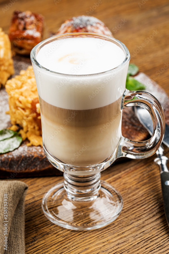 A glass of delicious latte on wooden table. A glass of delicious latte on wooden table.