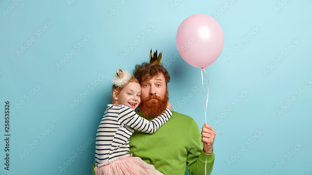 Φωτογραφία I love you, dad! Bearded redhead father plays with cute little girl, holds balloon, recieves hug from female child, dressed in festive clothes, celebrate Childrens Day together