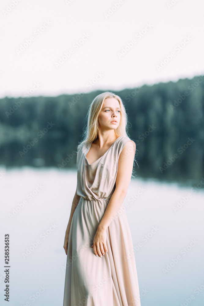 Girl in boudoir dress by the lake at sunset. Fees bride's on nature, harmony. Beautiful model, Russian girl with long hair Girl in boudoir dress by the lake at sunset. Fees bride's on nature, harmony. Beautiful model, Russian girl with long hair