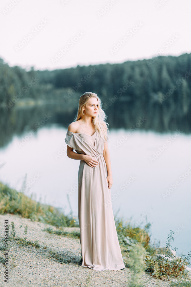 Girl in boudoir dress by the lake at sunset. Fees bride's on nature, harmony. Beautiful model, Russian girl with long hair Girl in boudoir dress by the lake at sunset. Fees bride's on nature, harmony. Beautiful model, Russian girl with long hair