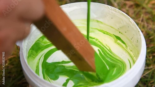 In white acrylic paint pour and mix the color with a wooden stick