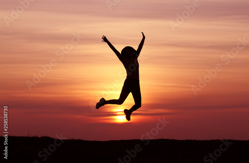 Silhouette of a girl jumping at sunset, athletic girl, happy, incredible sunset