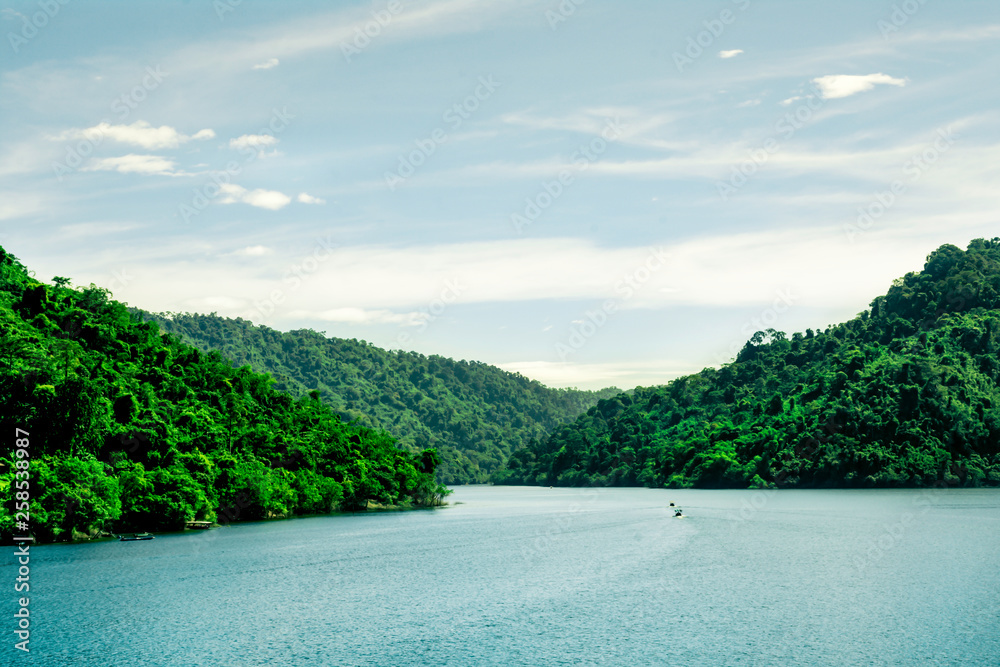 Beautiful landscape view of green mountain beside river on bright sky clouds, Water storage dam, Green tree nature mountain on riverside Beautiful landscape view of green mountain beside river on bright sky clouds, Water storage dam, Green tree nature mountain on riverside