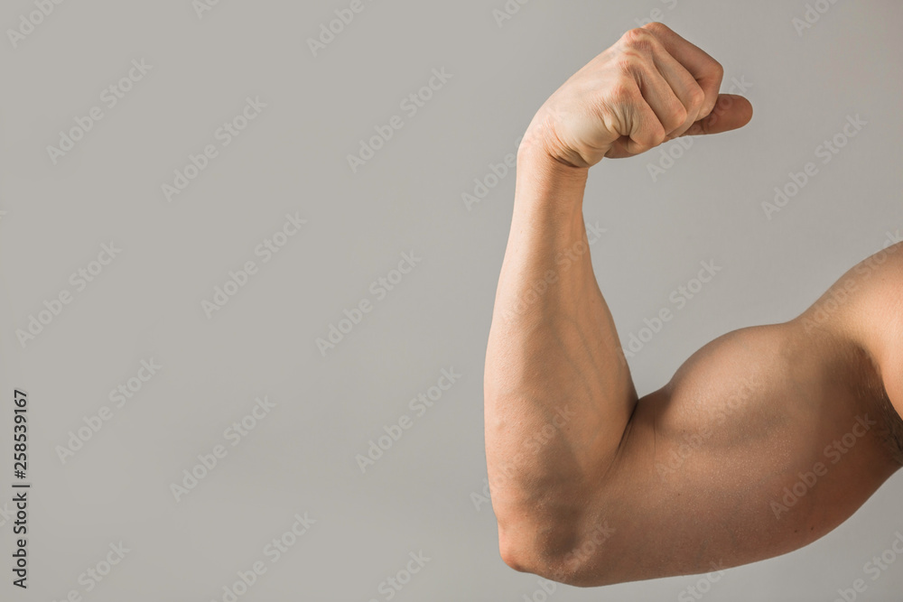 beautiful muscled hand with a muscle on a gray background beautiful muscled hand with a muscle on a gray background