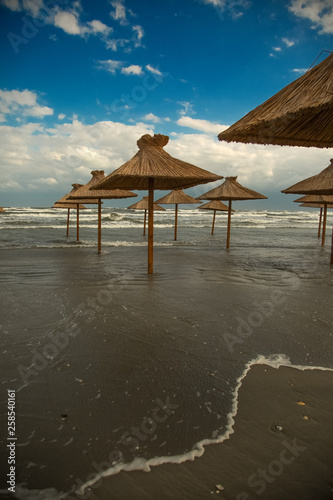 Beach with straw umbrellas under water