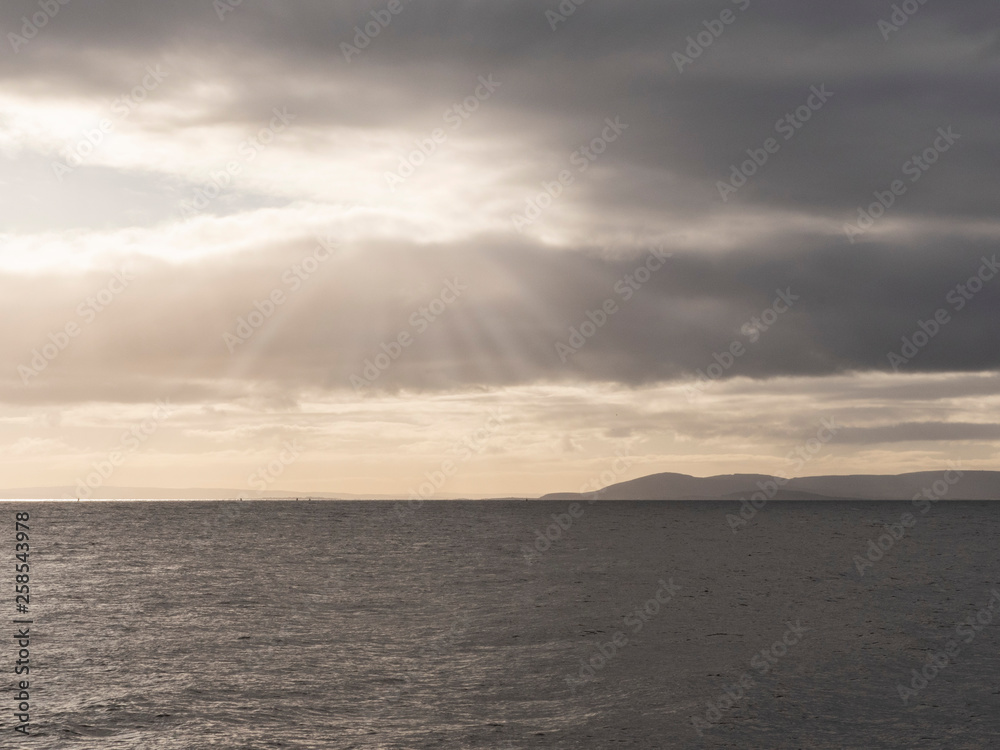 Atlantic ocean and Burren mountains, Galway bay, Ireland, Moody sky, sun ryes, calm and peaceful.