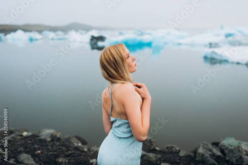 The girl is in a blue dress in the winter. The girl is blue icebergs. Girl on the ocean.