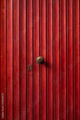 Red wooden retro door with small handle and keyhole. Minimalism concept. Background. © Andrey