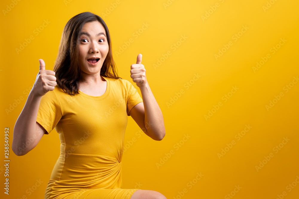 Happy woman thinking and standing isolated over yellow background Happy woman thinking and standing isolated over yellow background